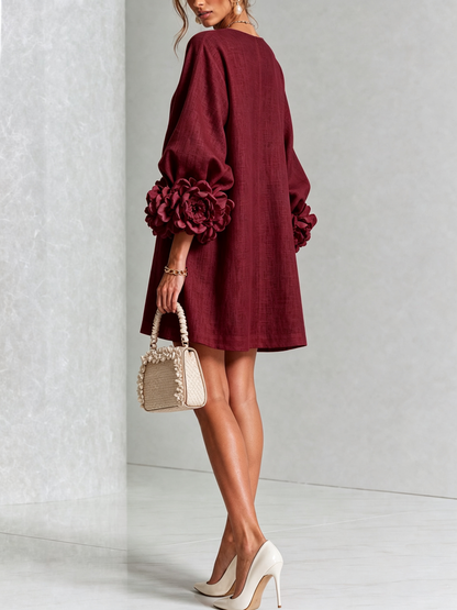 Back view of the burgundy dress on a model, showing the plain back and flower cuffs on the sleeves. 37