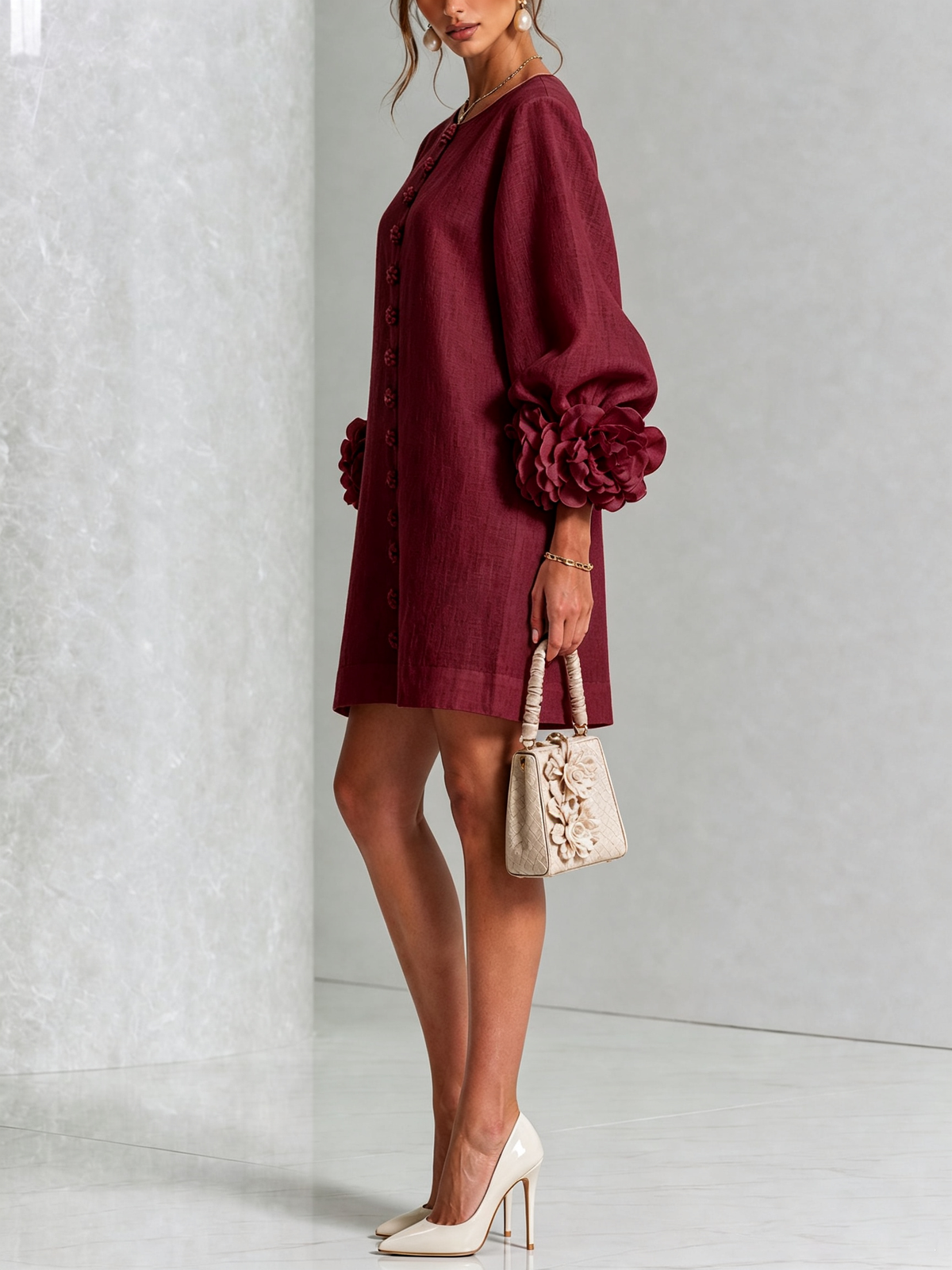 Side view of the burgundy dress on a model, showing the puffed sleeve ending in a large flower cuff. 36