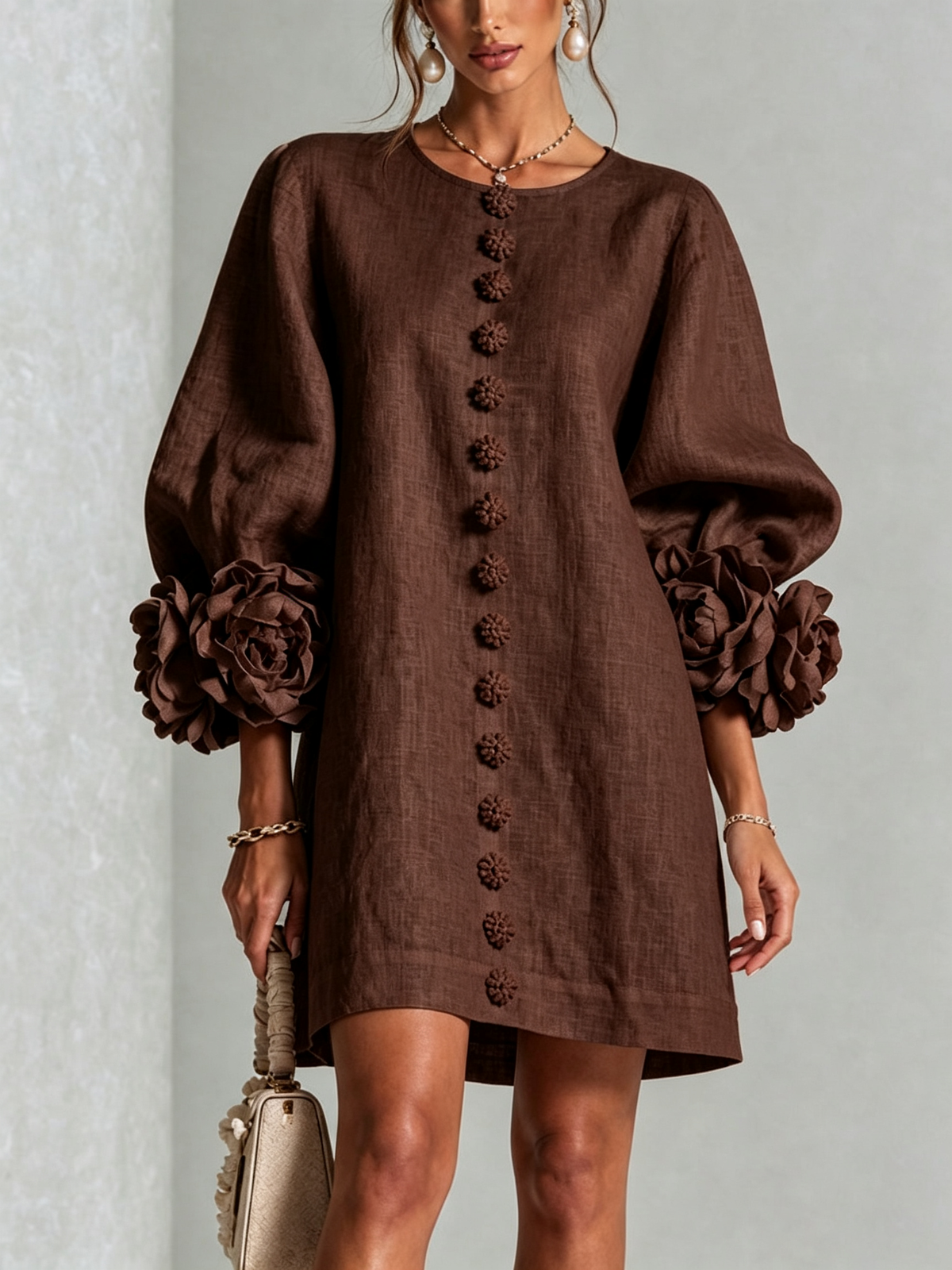 Close front view of the dark brown dress, with a row of textured flower buttons and large rose cuffs on puffed sleeves. 27
