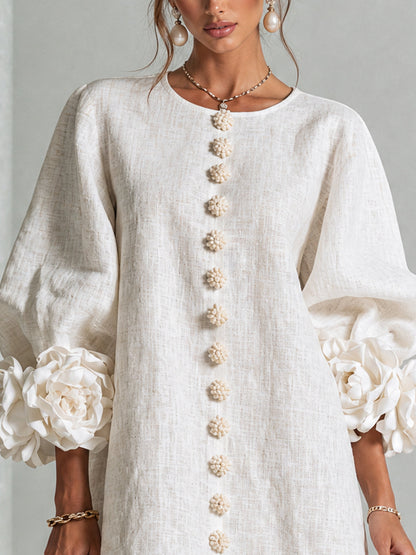 Close-up of the cream dress's round neckline, flower buttons and rose-trimmed puff sleeves 10
