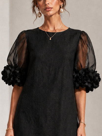 Close-up of the dress's upper half, showing the round neckline, textured fabric, sheer puff sleeves and gathered floral appliqué cuffs. 5