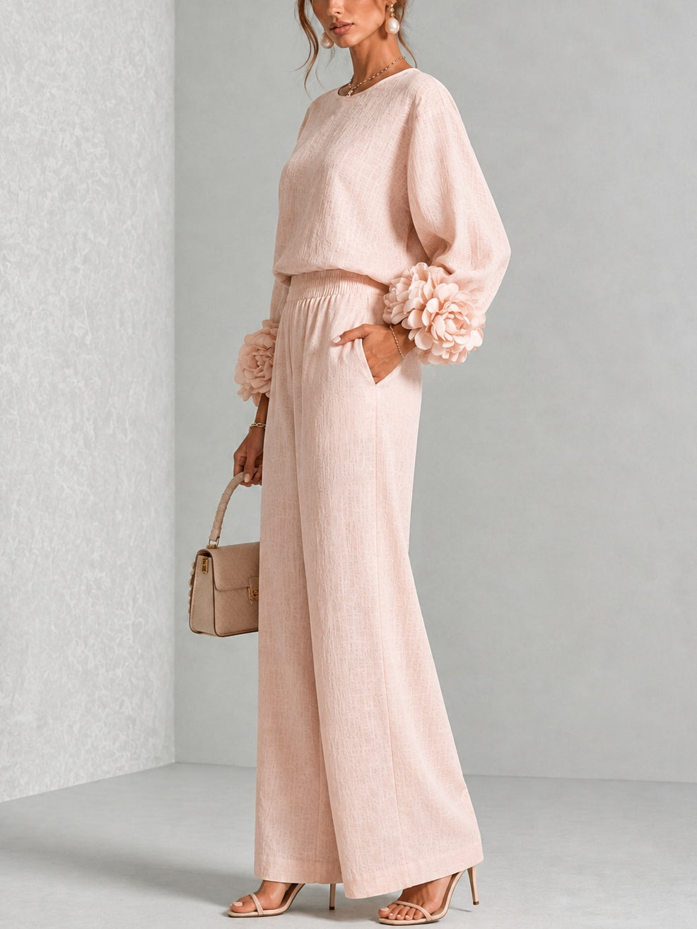 Three-quarter side view of the pink set, hand in pocket, with sleeve flowers and wide trousers in view 10