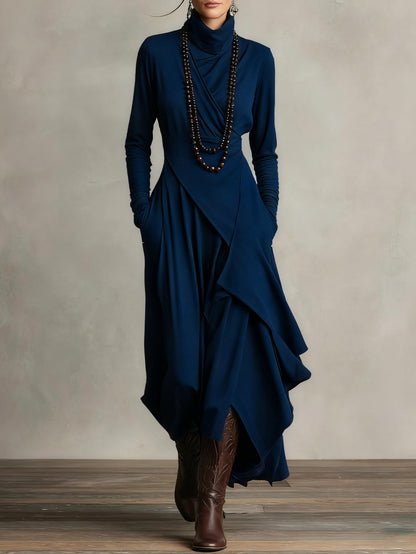 Front view of the dress in deep navy blue, styled with beaded necklaces and brown boots 10