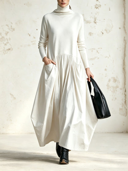 Front view of the dress in cream white, with a hand in the pocket and a black bag 5