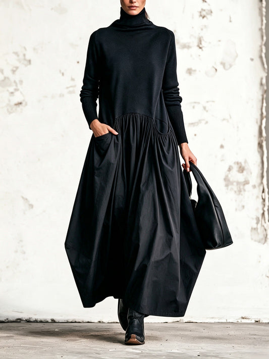 Model walking in the black dress with one hand in a gathered side pocket, holding a black bag 1