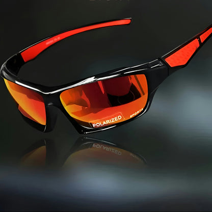 Sunglasses with orange-red mirrored lenses and red arm inserts, angled view on a dark reflective surface 6