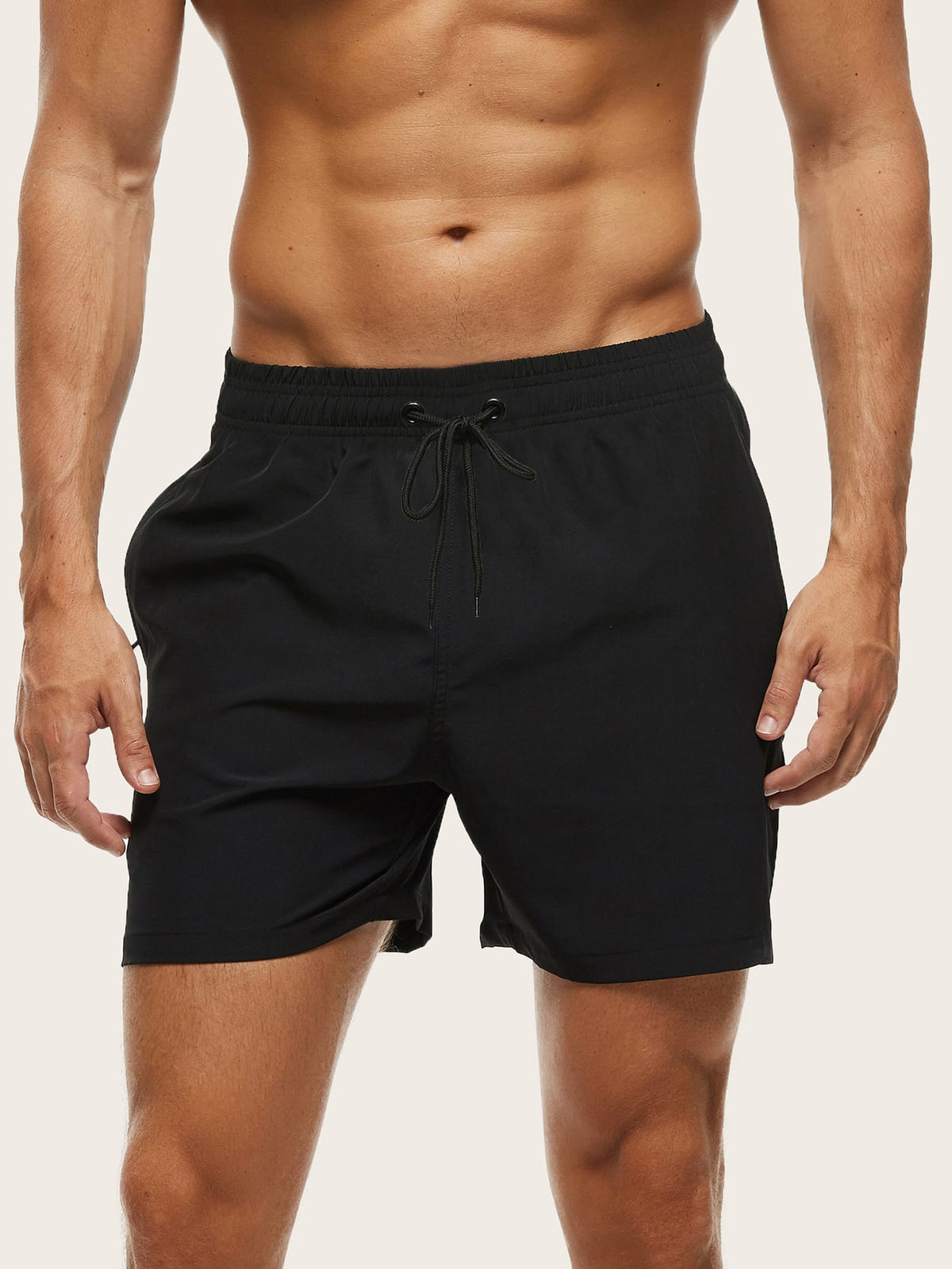 Front view on a model of black swim shorts with a matching drawstring and relaxed fit. 10