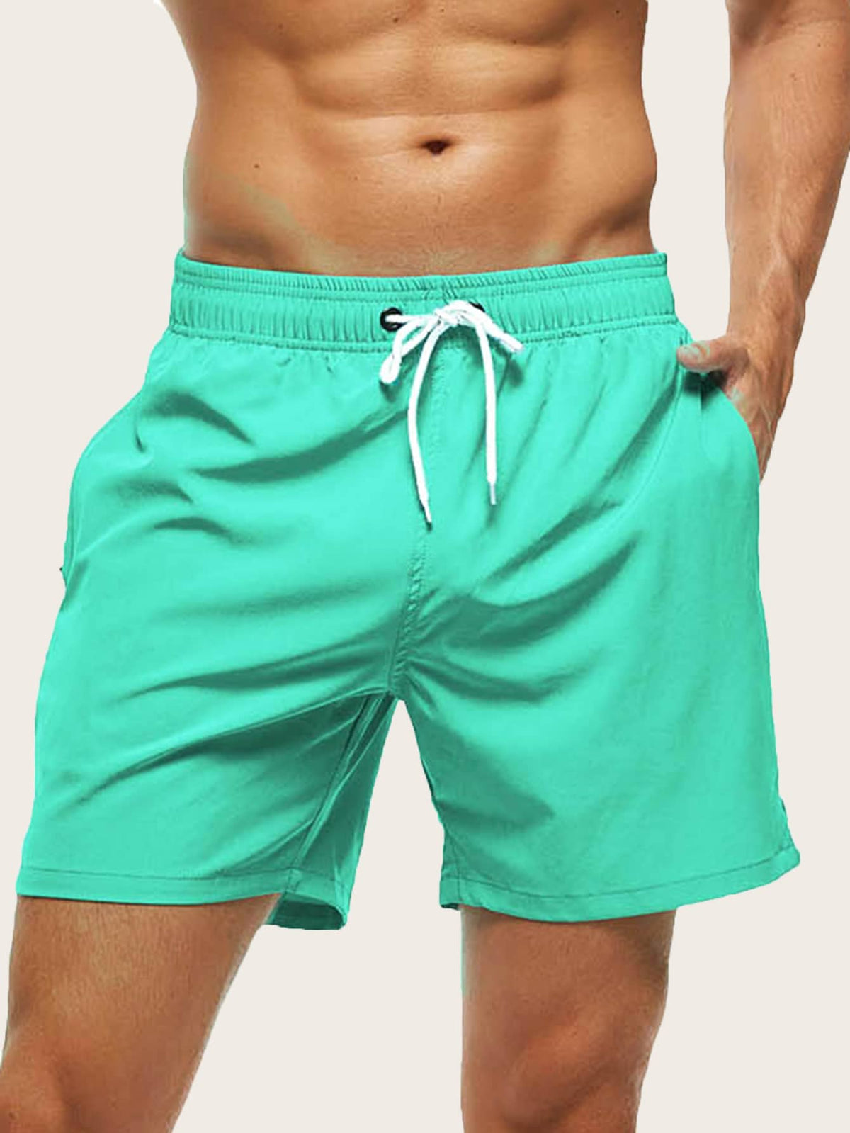 Close front view of turquoise swim shorts with a white drawstring, one hand in the pocket. 13
