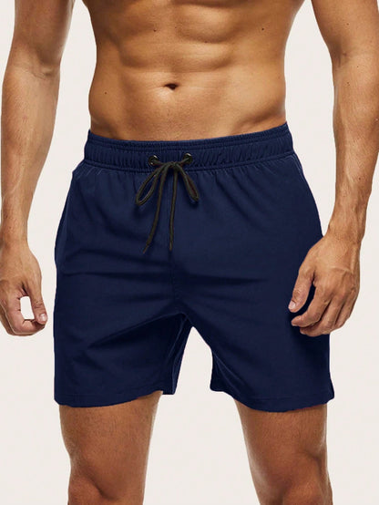 Front view on a model of navy blue swim shorts with elasticated waistband and black drawstring. 14