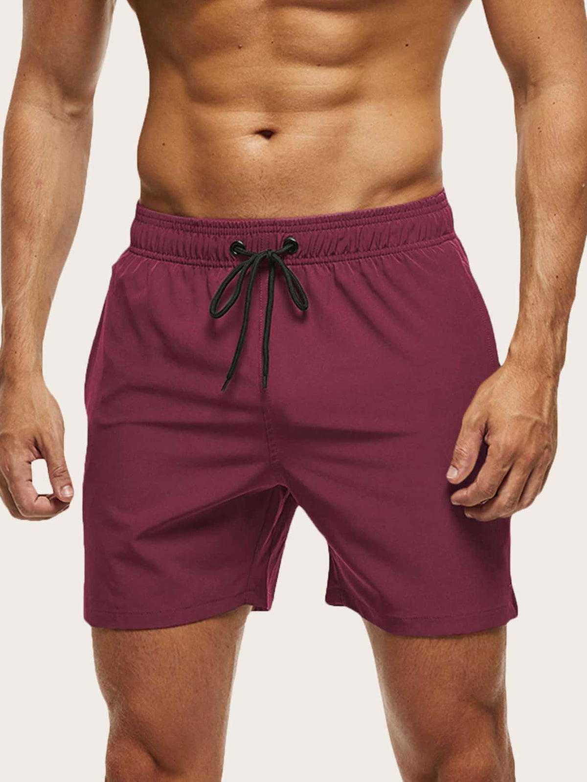 Front view on a model of burgundy swim shorts with a black drawstring tie at the waistband. 8