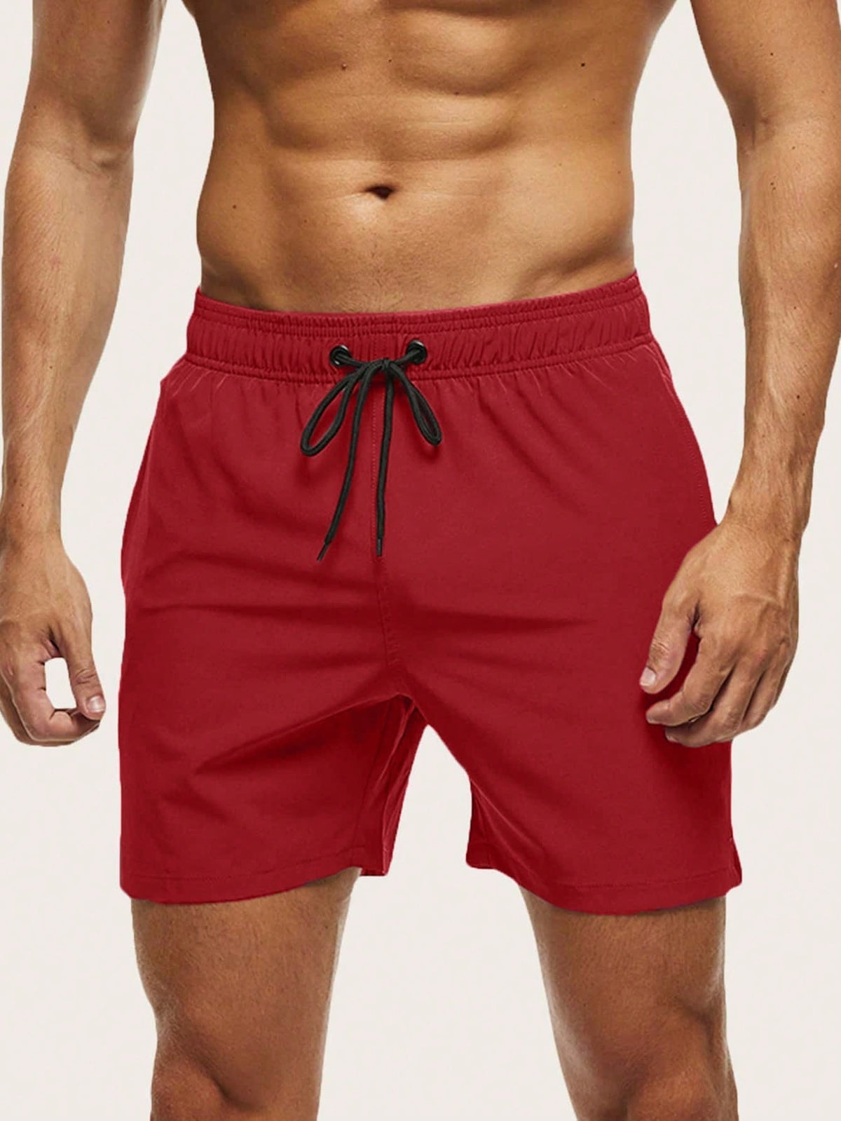 Front view on a model of red swim shorts with an elasticated waist and black drawstring. 1