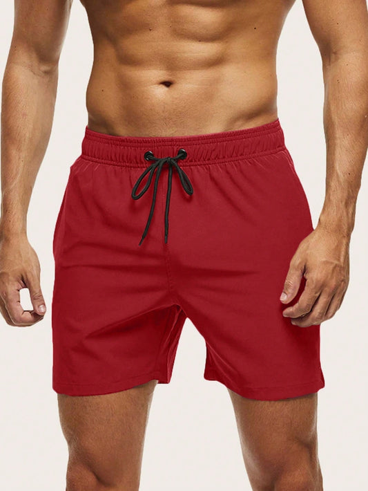 Front view on a model of red swim shorts with an elasticated waist and black drawstring. 1