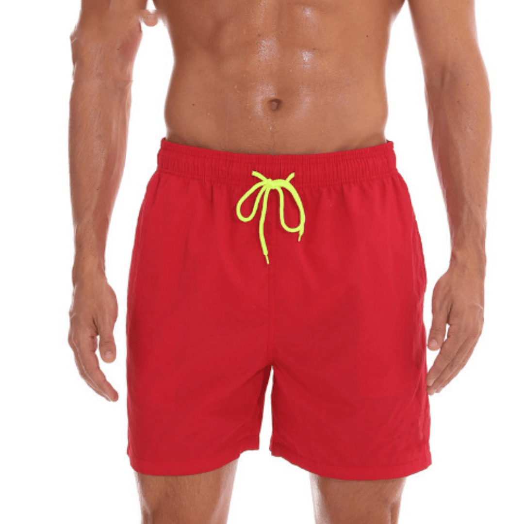 Red swim trunks with a neon yellow drawstring, worn by a model with arms relaxed at his sides. 10