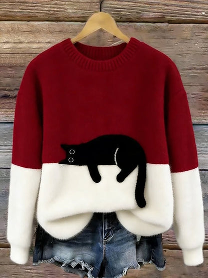 Red and white colour-block fluffy jumper on a wooden hanger, with a black cat lying along the colour join. 7