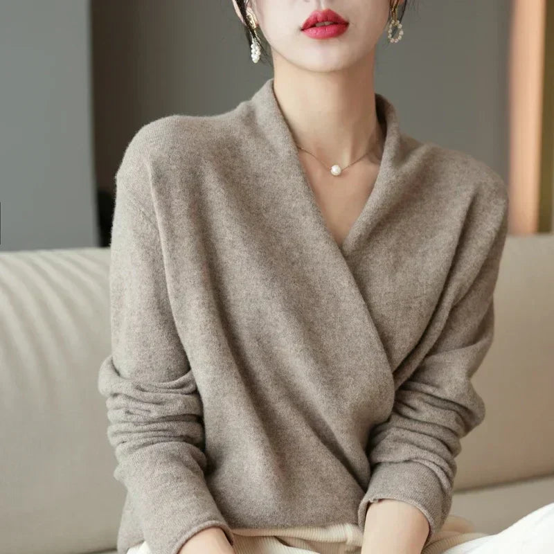 Taupe wrap-front jumper worn by a seated model, shown from the front with sleeves relaxed 9