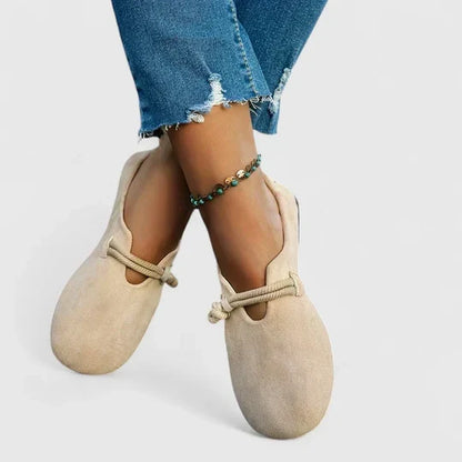 Beige loafers with rope ties worn by a model with crossed ankles, front view 3