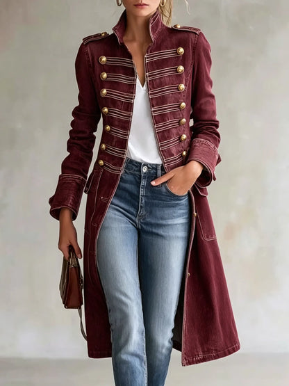 Model wearing the coat in a deep burgundy version with gold buttons and pale braiding, styled with a white top and jeans. 11