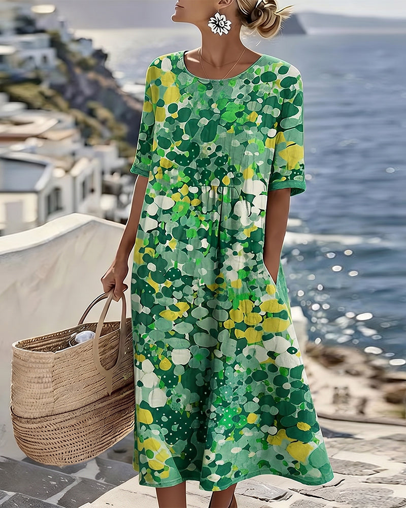 Model wearing the dress in a green and yellow abstract floral print, holding a woven basket 5