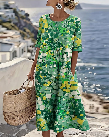 Model wearing the dress in a green and yellow abstract floral print, holding a woven basket 5