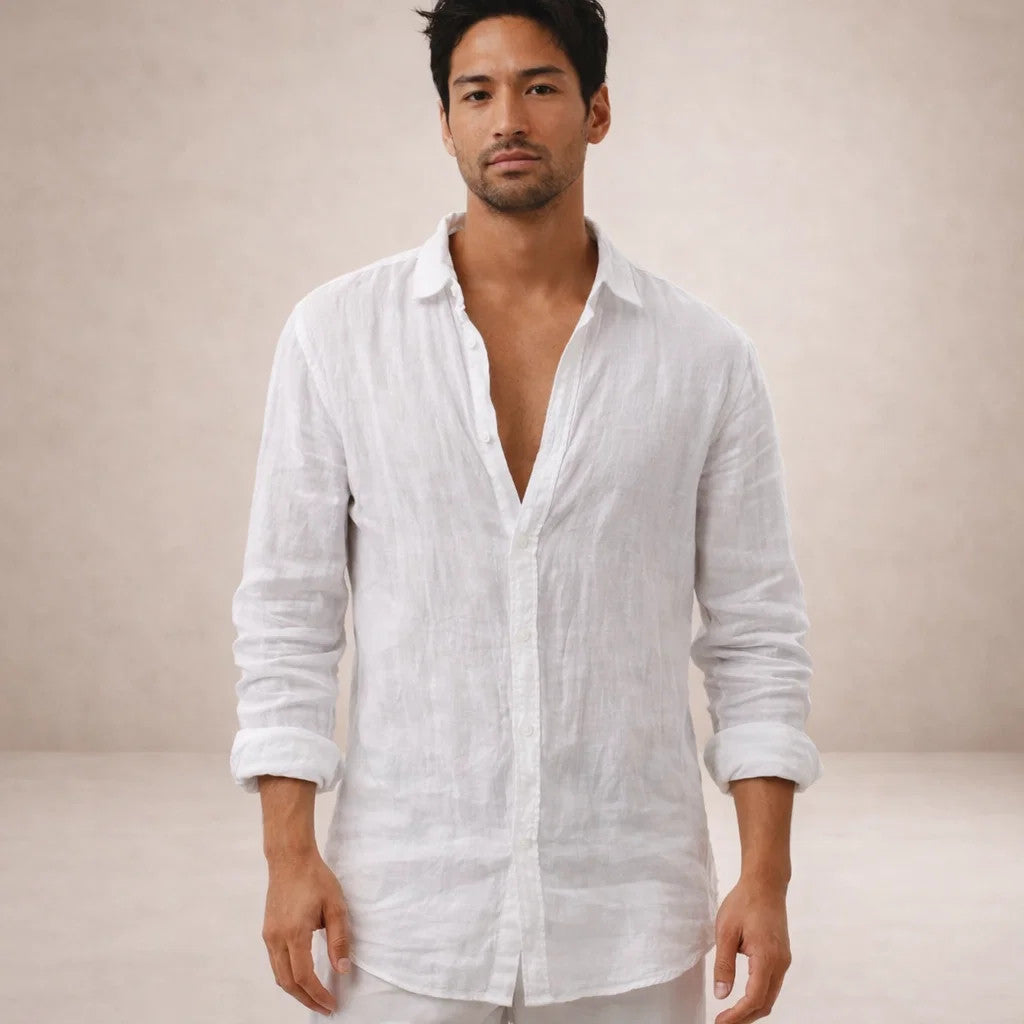Model facing the camera in a white linen shirt worn open at the neck, with sleeves rolled and white trousers. 9