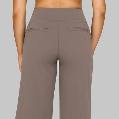 Back view of the taupe trousers showing the wide waistband, centre seam and two slim welt pockets. 4