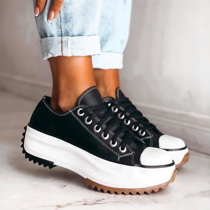 Black lace-up platform trainers with white stitching, worn with rolled light-blue jeans, showing the thick white sole and gum outsole. 3
