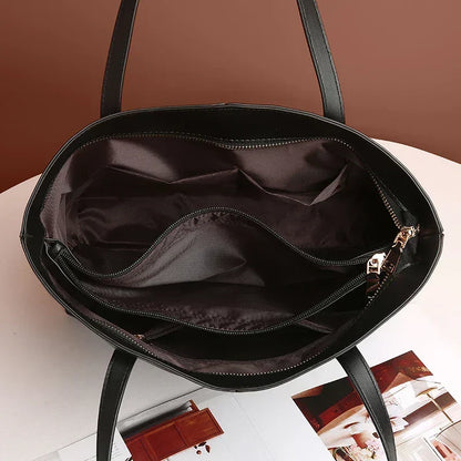 Inside of the black tote from above, showing a zipped pocket and open compartments in dark lining 5
