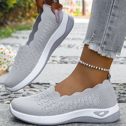 Light grey knit slip-on shoes, one held up to show the lining, the other worn 10