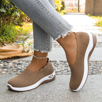 Brown knit slip-on shoes with scalloped collar and white midsole worn on a stone path 20