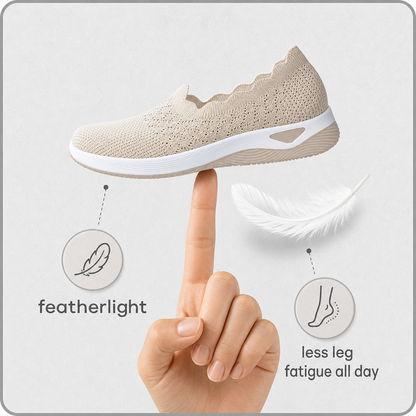 Beige knit shoe balanced on a fingertip beside a white feather, illustrating how light it is 3