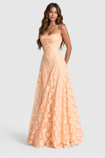 Peach daisy-patterned lace gown with ruched cowl bodice and fine straps, model standing front-on with hands behind her. 6