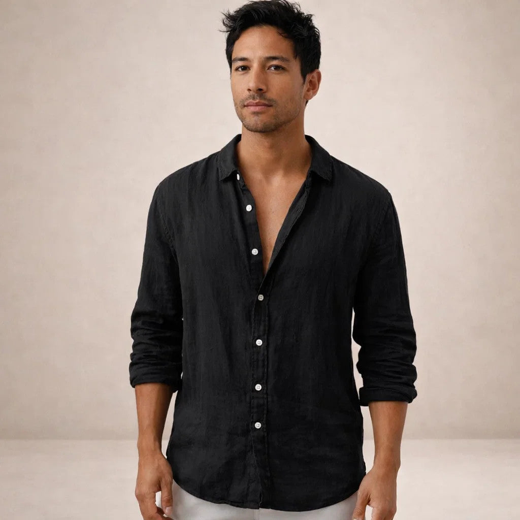 Model facing the camera in a black linen shirt with white buttons, top buttons undone and sleeves rolled to the forearm. 10