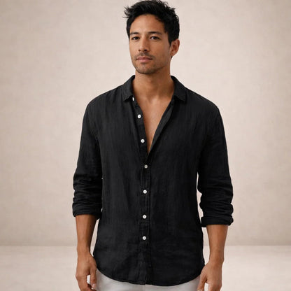 Model facing the camera in a black linen shirt with white buttons, top buttons undone and sleeves rolled to the forearm. 10
