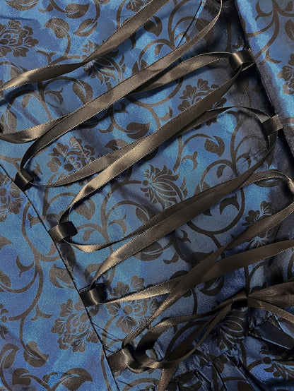 Close-up of the black satin ribbon lacing across the navy floral brocade fabric at the back of the dress. 5