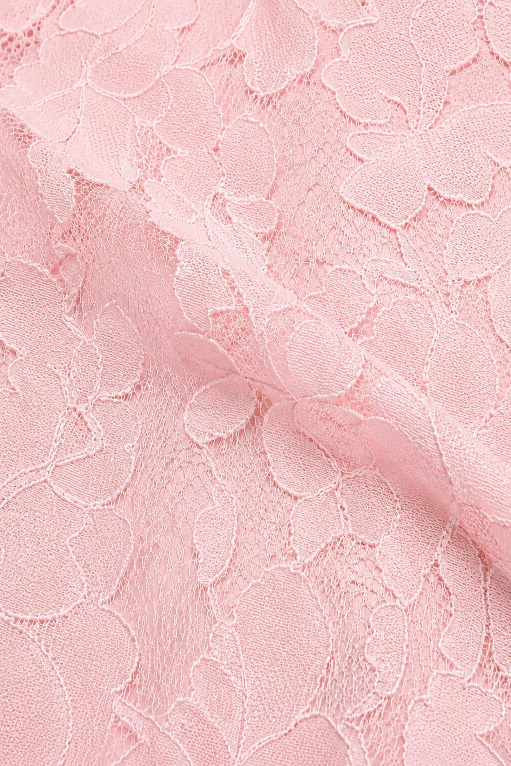 Close-up of soft pink floral lace fabric with scalloped flower outlines and fine net background, gently folded. 17
