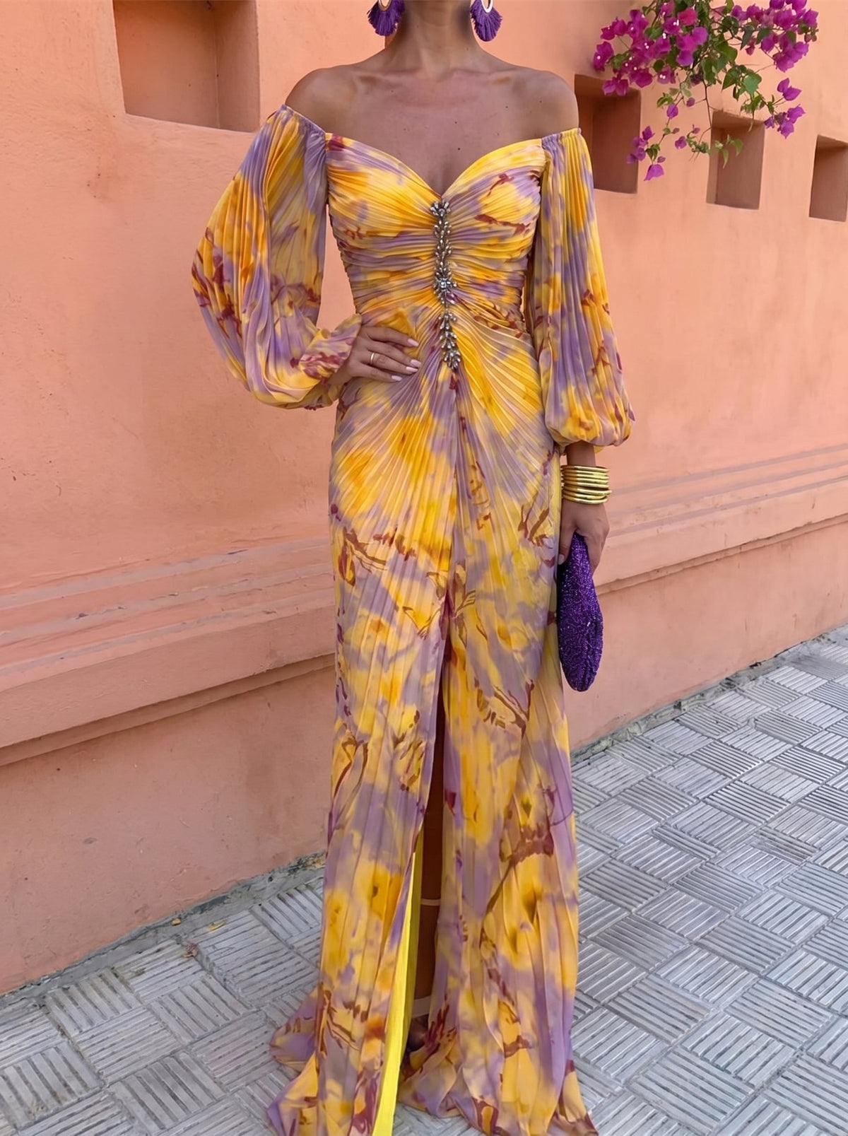 Close front view of the off-shoulder pleated bodice with crystal embellishment down the centre, balloon sleeves and front thigh slit. 2