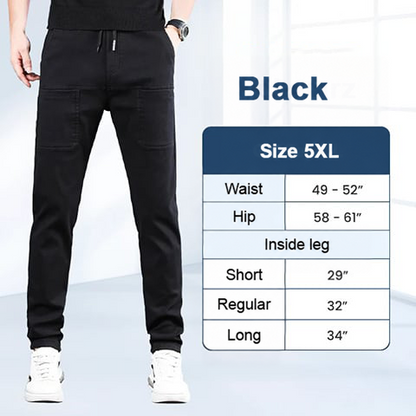 Man wearing black drawstring trousers with white trainers, beside a size chart listing waist, hip and inside leg 26