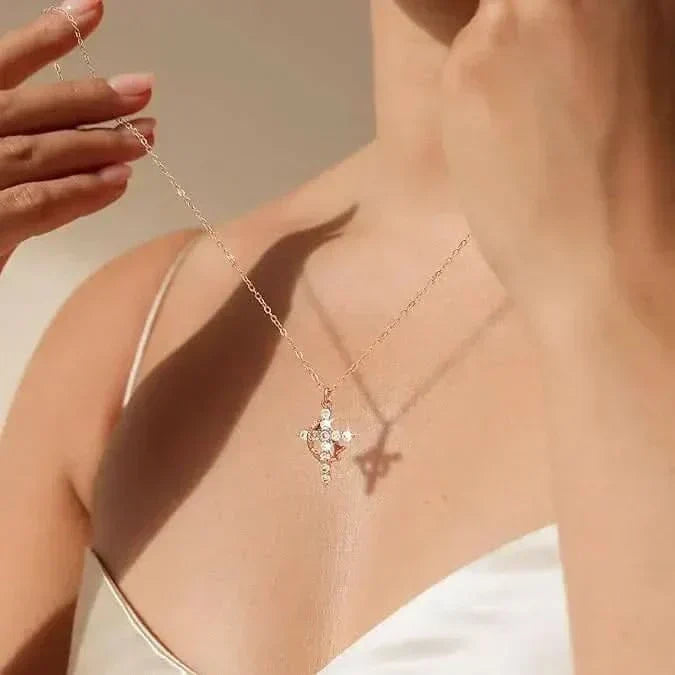 Close crop of a model in a white top lifting the chain, cross pendant resting on her chest 3
