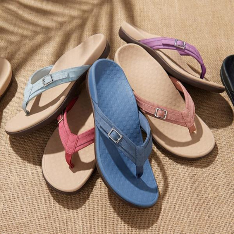 Several buckled thong sandals in blue, pink, purple and light blue arranged on woven matting 11