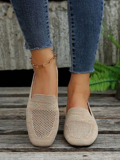 Front view of beige mesh slip-ons with pink flecks, worn with raw-hem jeans and a gold chain anklet on wooden slats. 3
