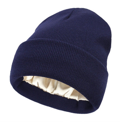 Navy blue ribbed knit beanie with folded cuff, showing the cream satin lining inside 11