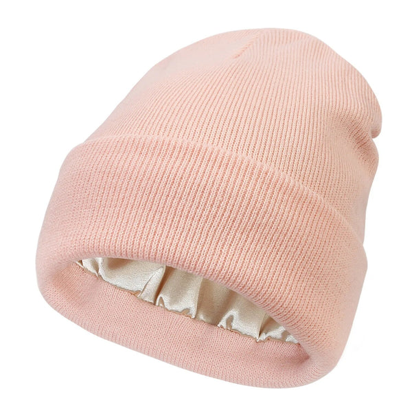 Pale pink ribbed knit beanie with folded cuff, revealing the cream satin lining inside 4