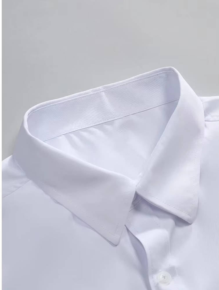 Close-up of the white shirt's pointed collar and stitched edges, laid flat on a pale grey surface 11