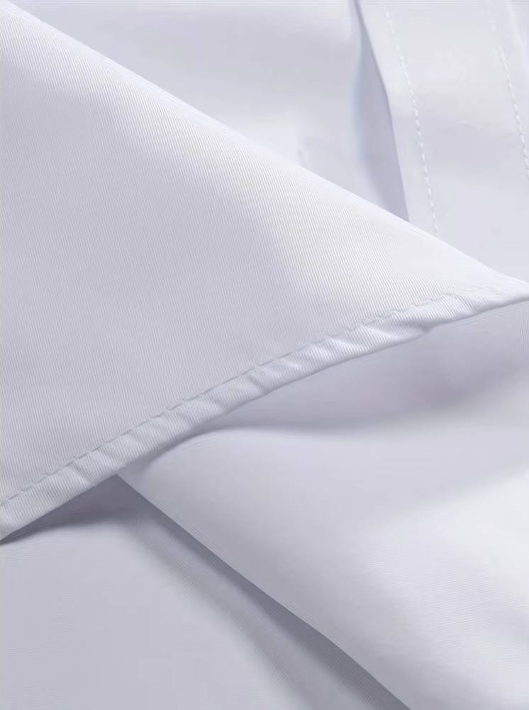 Extreme close-up of the white fabric's fine twill weave, a folded collar edge and neat topstitching 12
