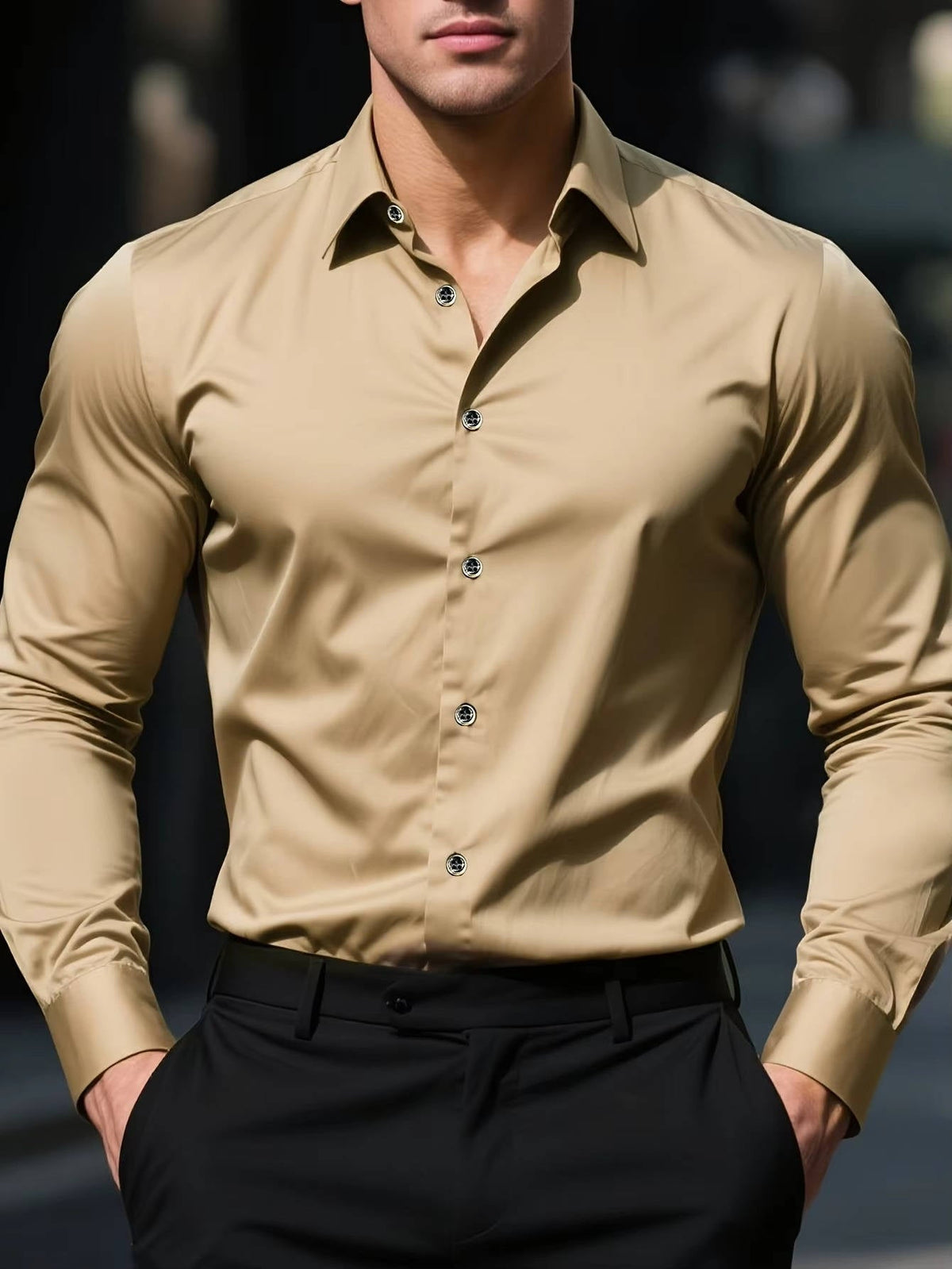 Model wearing the shirt in beige with dark buttons, tucked into black trousers, hands in pockets 7