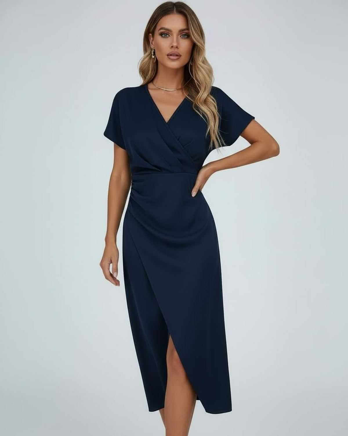 Model wearing the short-sleeved wrap dress in navy blue, one hand resting on her hip 3