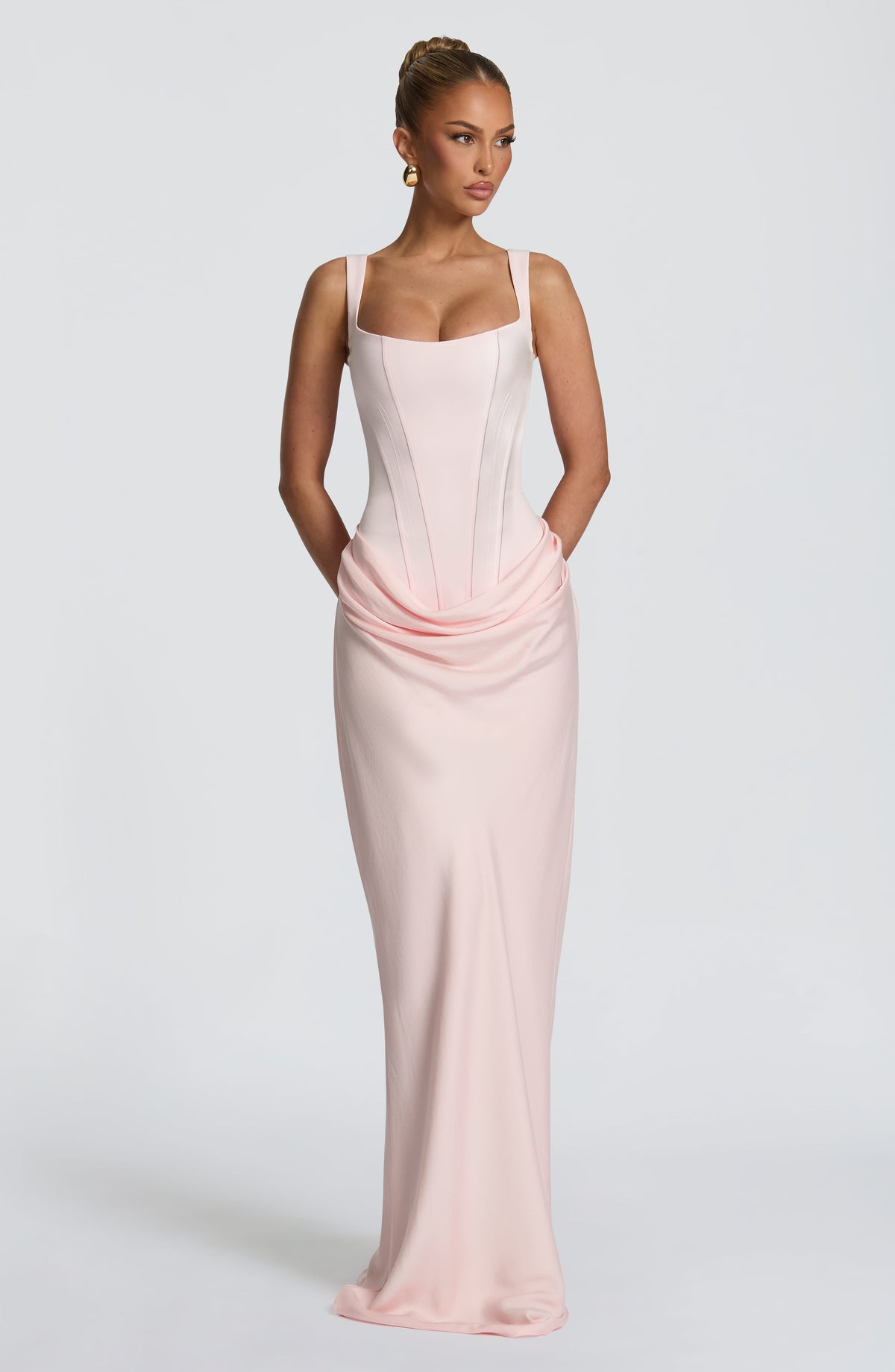 Light pink maxi dress with a square-neck corset bodice and draped hip, worn with hands behind the back 13