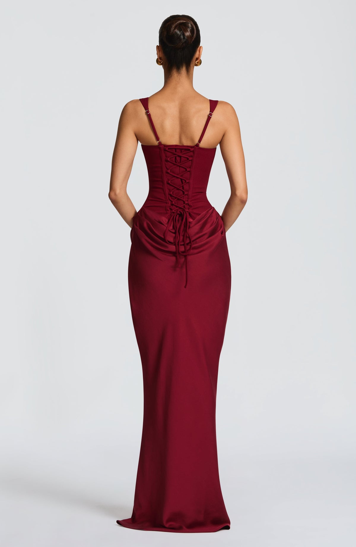 Back view of the burgundy maxi dress showing the corset lace-up back, adjustable thin straps and gathered drape at the hips. 23
