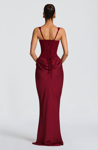 Back view of the burgundy maxi dress showing the corset lace-up back, adjustable thin straps and gathered drape at the hips. 23