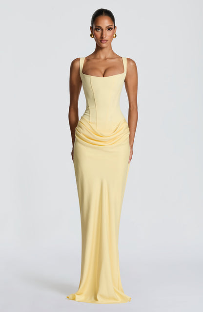 Pale yellow maxi dress seen from the front, with a square neckline, corset seaming and draped hip detail 9
